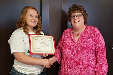 Pam Delo from Forward Bank presents Brianna North of Greenwood High School with $500 scholarship.