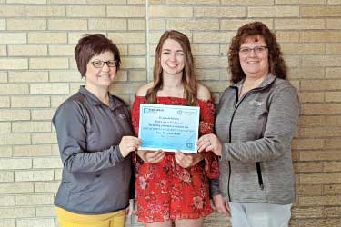 Traci Geiger and Vicky Fischer from Forward Bank present Katerina Kolzow from Colby High School with $500 scholarship.