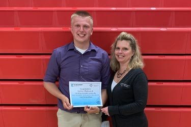 Kelly Booth from Forward Bank presents Dalton Matkovich from Owen-Withee High School with $500 scholarship.