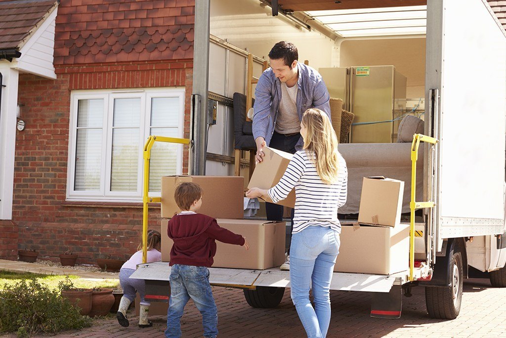 family loading up moving truck with boxes