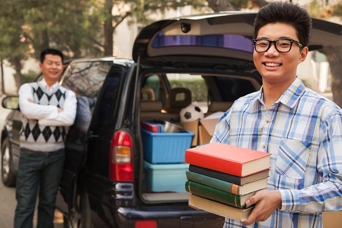 parent helping son pack up car to leave for college