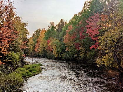 colorful fall trees line each side of the river