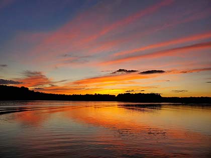 beautiful blue, pink, and yellow sunset reflecting on calm lake