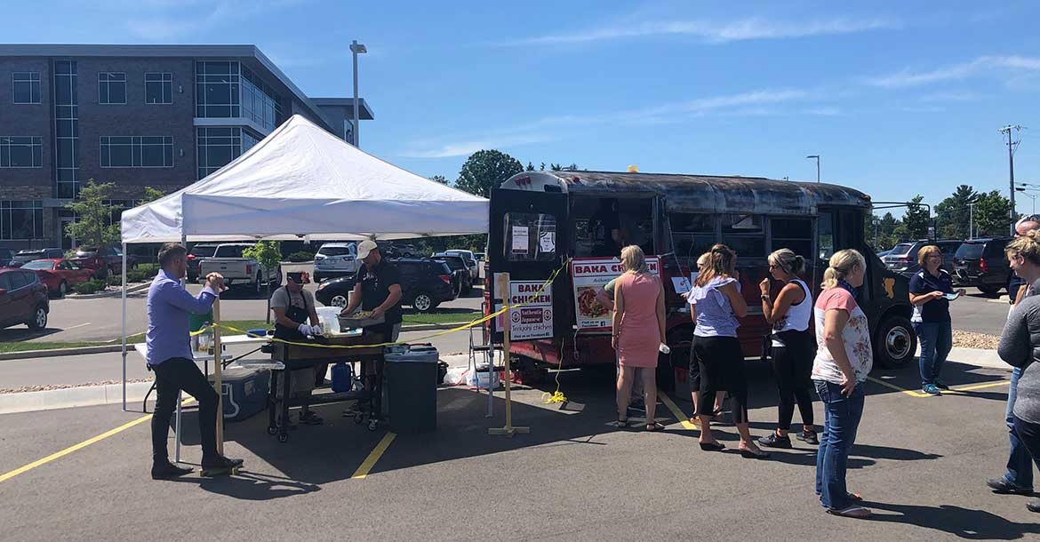 patrons wait in line at Baka Chicken during Food Truck Fridays at Forward Bank in Marshfield