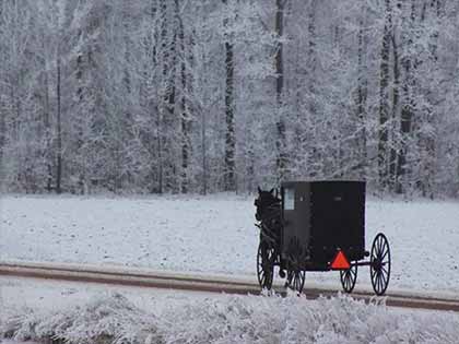 horse drawn Amish buggy going down road on winter day 