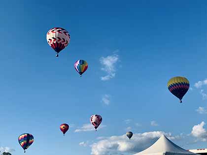 several hot air balloons soaring in the blue sky