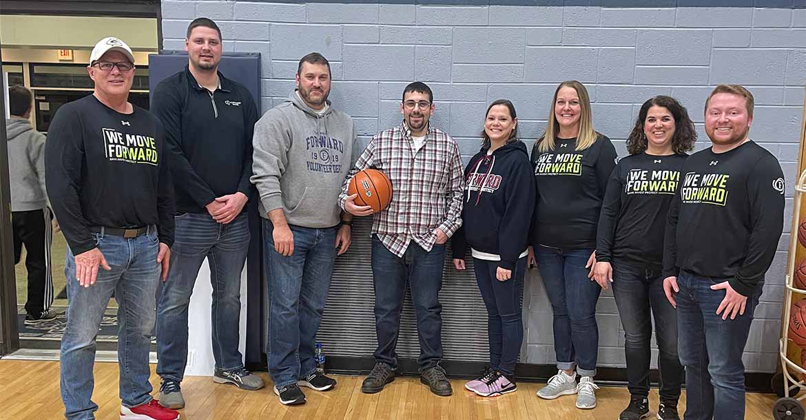Forward Bank employees pose for group photo in the gym at the Columbus Catholic High School basketball game 