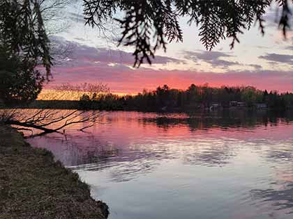 pink sunset reflecting on calm lake in the summer