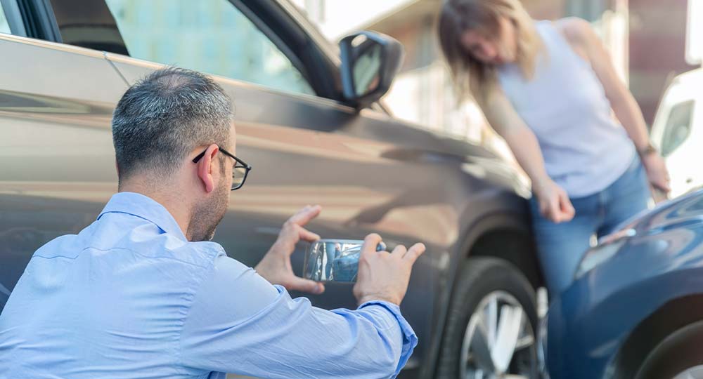 Taking photos of car accident for insurance claim process.
