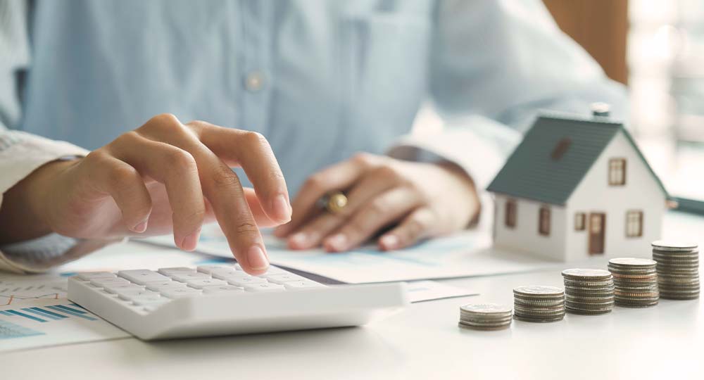 Person calculating mortgage payments representing how Federal Reserve rate changes affect home loans in Wisconsin and Minnesota.