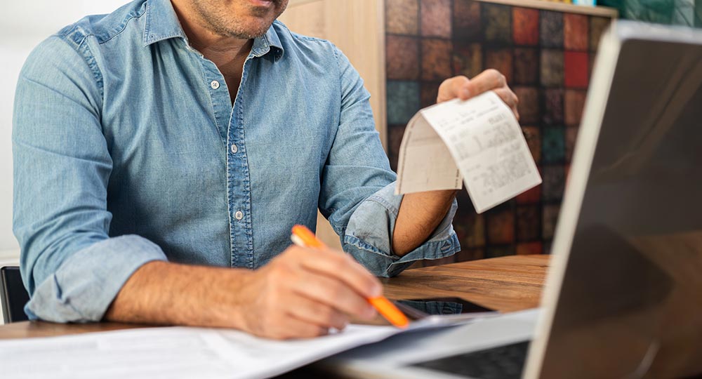 Individual organizing receipts and financial records while preparing for tax season.