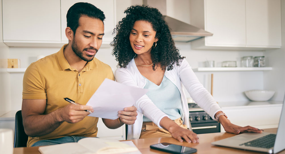 Couple reviewing tax documents on a laptop at home during tax season.