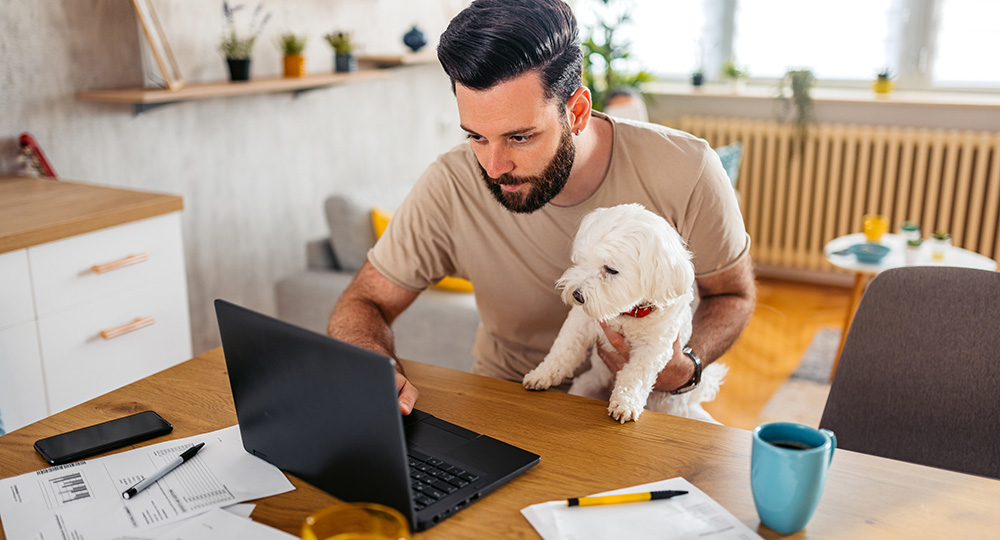 Guy with his dog working on financial budgeting