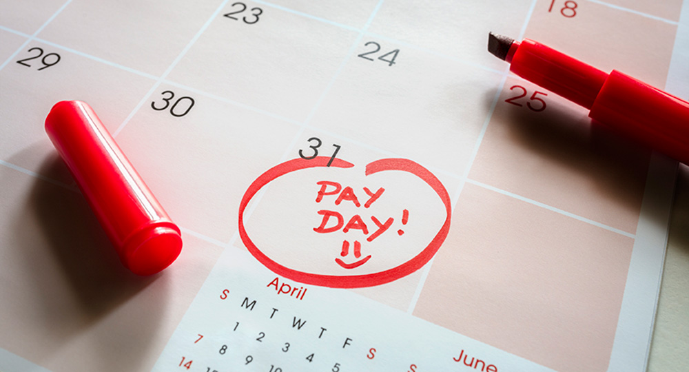 Calendar with a payday circled, representing receiving a first paycheck and budgeting for future expenses.