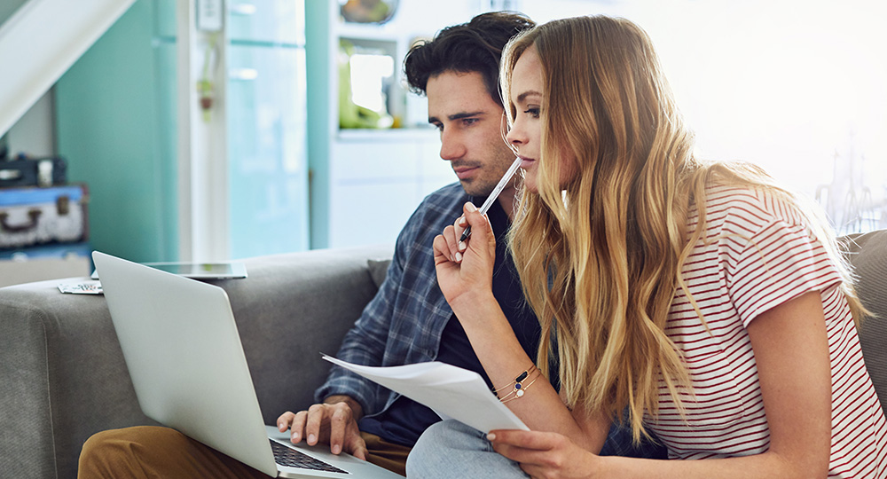 Young couple reviewing their banking options on laptop